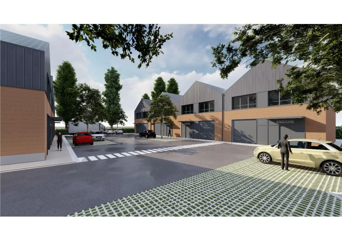 Cour intérieure : bâtiment B avec portes sectionnelles et bureaux en mezzanine, parking engazonné