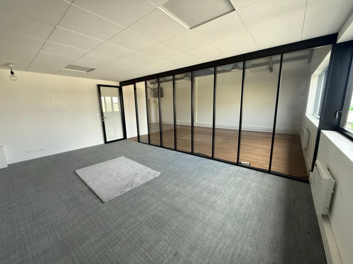 L'espace réunion vu de l'intérieur : cloison vitrée, sol en moquette, fenêtre